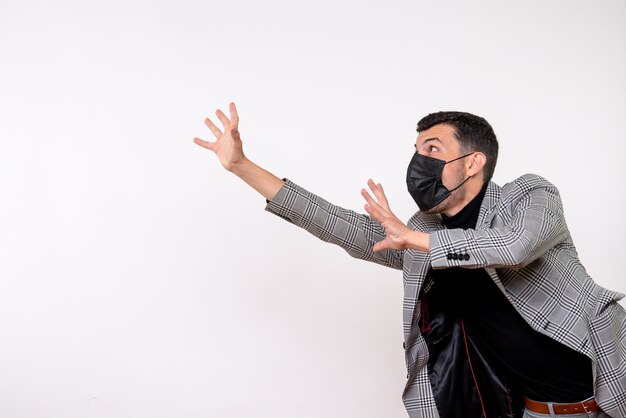 Front view handsome male in suit trying to catch something standing on white background