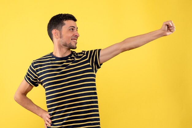 Front view handsome man in black and white striped t-shirt yellow isolated background