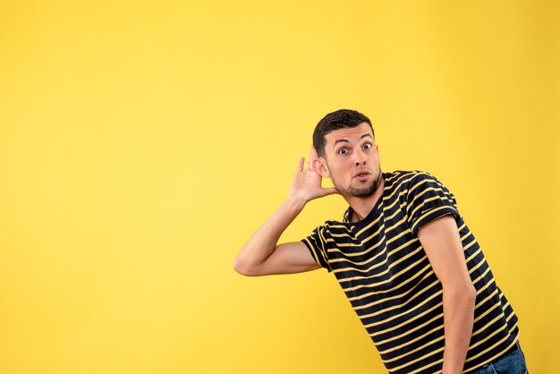 Front view handsome man in black and white striped t-shirt yellow isolated background
