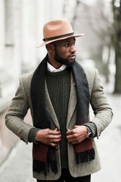 Free photo front view handsome man in grey jacket walking outdoors