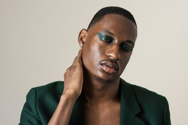 Front view of handsome man posing in blazer and wearing make-up