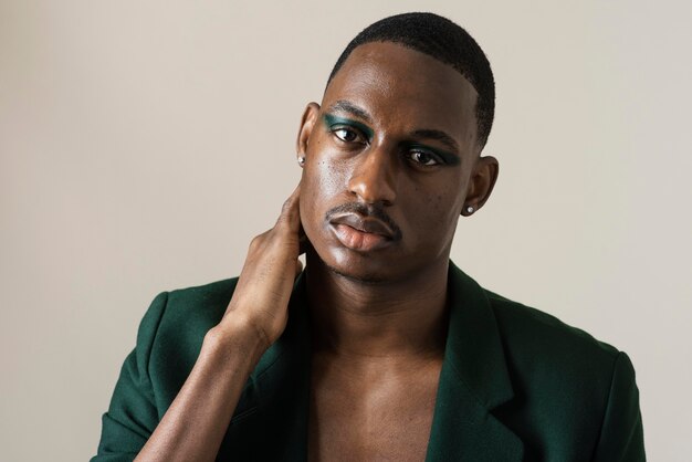 Front view of handsome man posing in blazer and wearing make-up