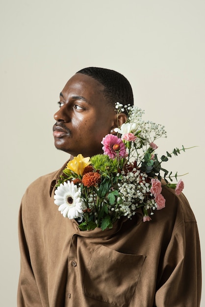 Front view of handsome man posing with bouquet of flowers