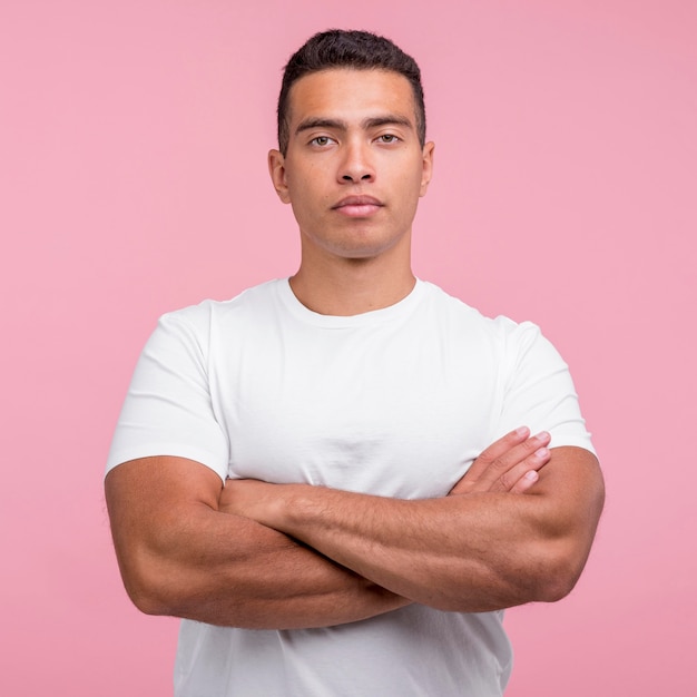Free photo front view of handsome man posing with his arms crossed