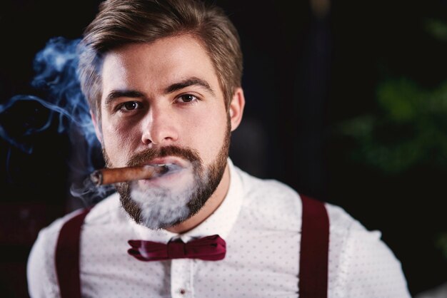 Front view of handsome man smoking cuban cigar