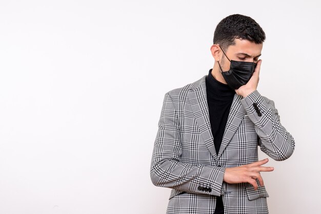 Vista frontale uomo bello in tuta tenendo il viso in piedi su sfondo bianco isolato