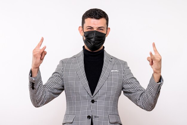 Front view handsome man in suit making wolf sign standing on white isolated background