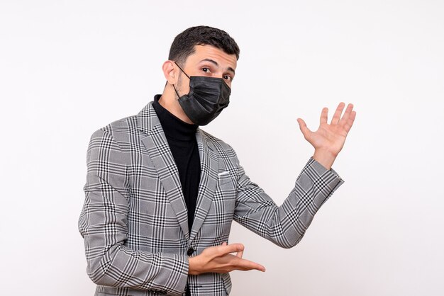 Front view handsome man in suit pointing at back standing on white isolated background