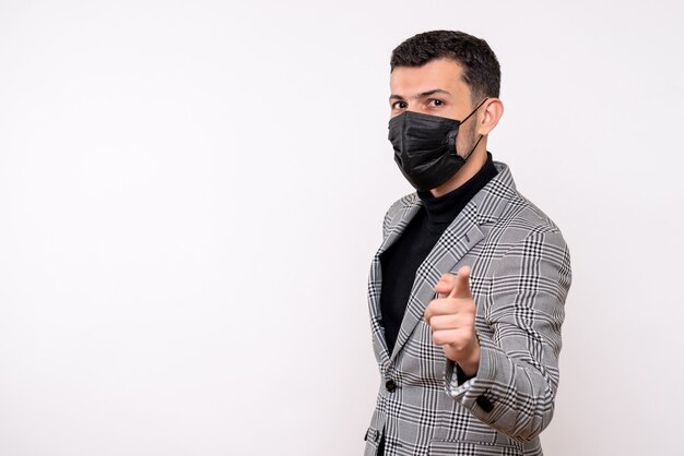 Front view handsome man in suit pointing at camera standing on white isolated background