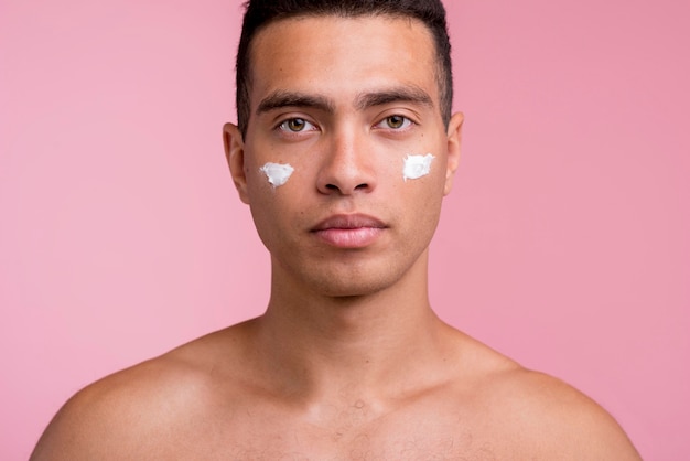 Front view of handsome man with face cream on