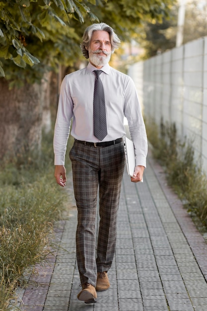 Free photo front view handsome mature male walking
