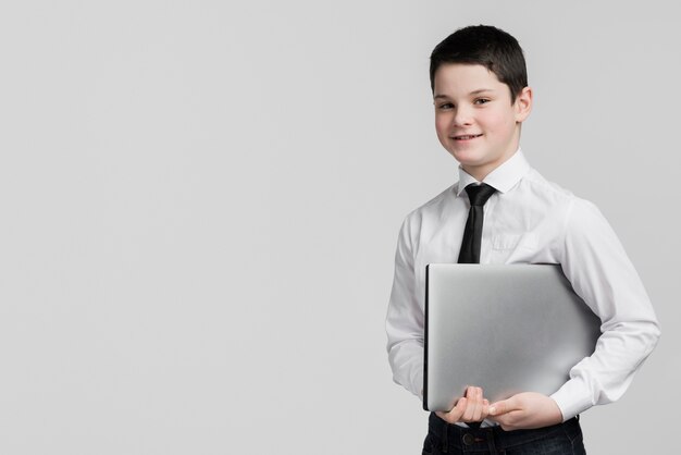 Front view handsome young boy holding laptop