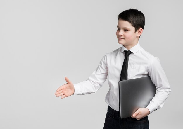 Front view handsome young boy holding laptop