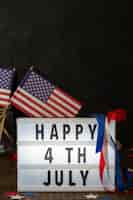 Бесплатное фото Вид спереди счастливого 4 июля знак с флагами и копией пространства