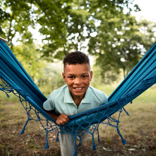 Free photo front view of happy boy in hammock