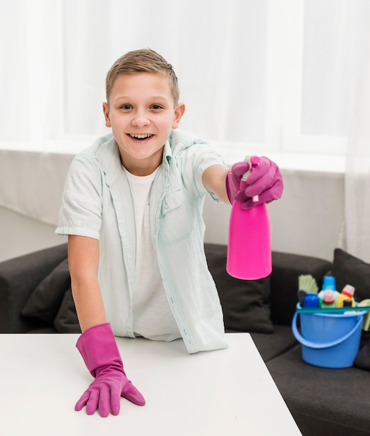 Front view of happy boy posing while cleaning