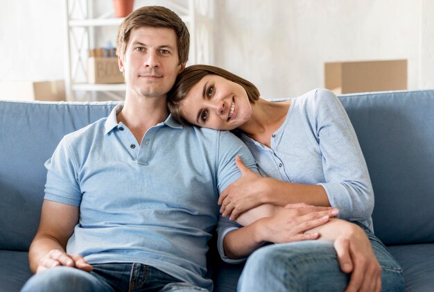 Вид спереди счастливой пары на диване во время упаковки для переезда