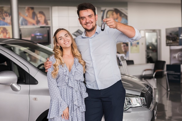 Front view happy couple holding car keys