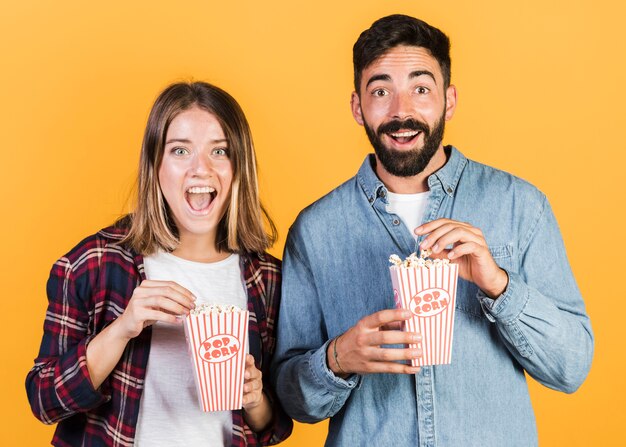 Front view happy couple with popcorn