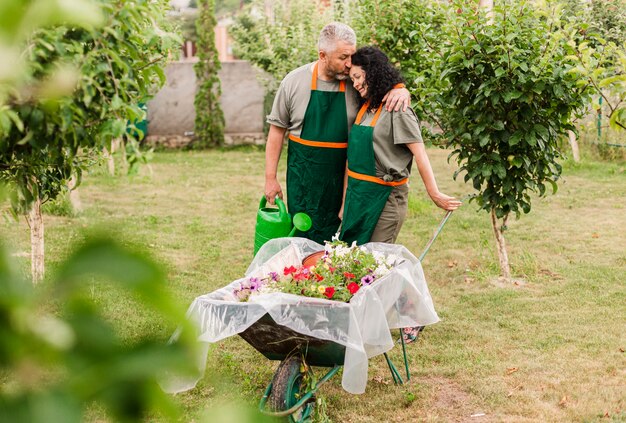 Front view happy couple with wheelbarrow