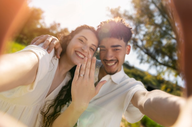 Front view happy engaged couple  in nature