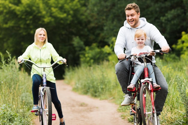 Front view happy family on bikes