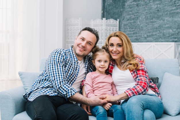 Free photo front view of happy family sitting on sofa