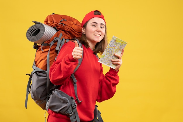 Front view happy female backpacker holding travel map giving thumb up