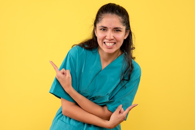 Front view happy female doctor standing on yellow background