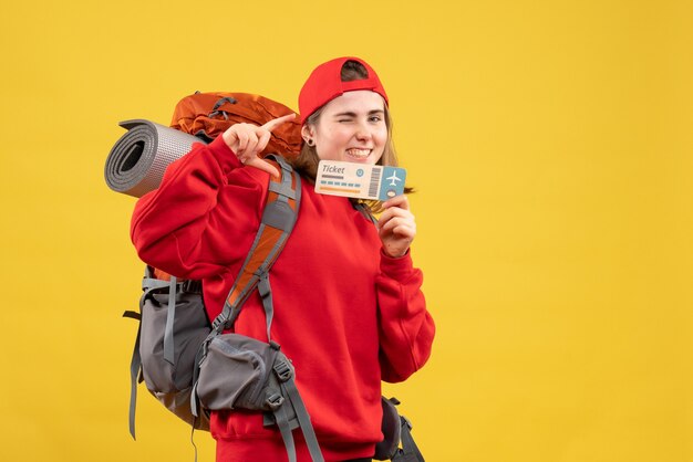 Front view happy female hiker with backpack holding plane ticket