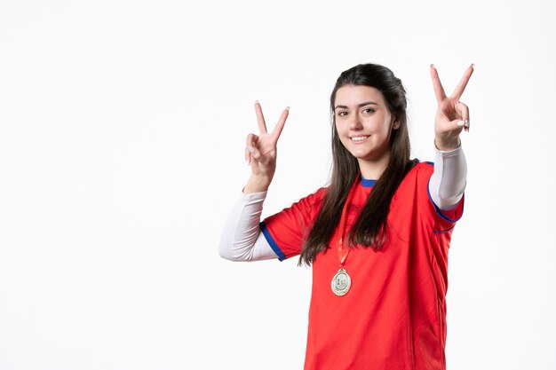 メダルとスポーツ服で幸せな女性プレーヤーの正面図