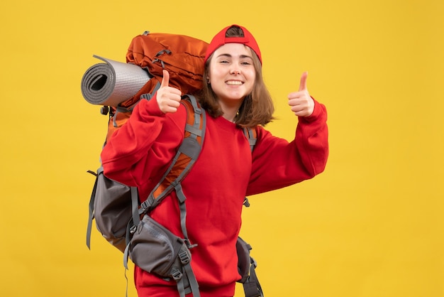 Front view happy female traveler with backpack giving thumbs up