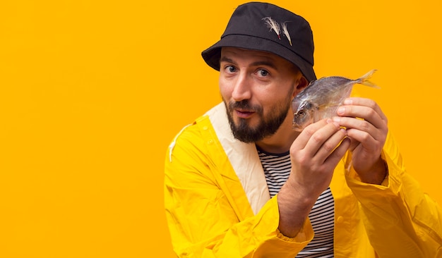 Free photo front view of happy fisherman holding catch with copy space