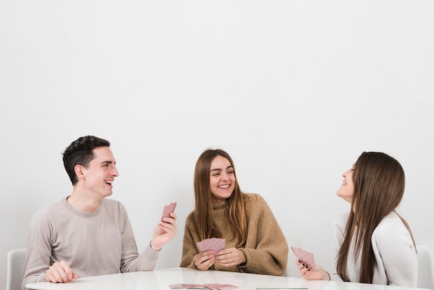 Front view happy friends playing cards game