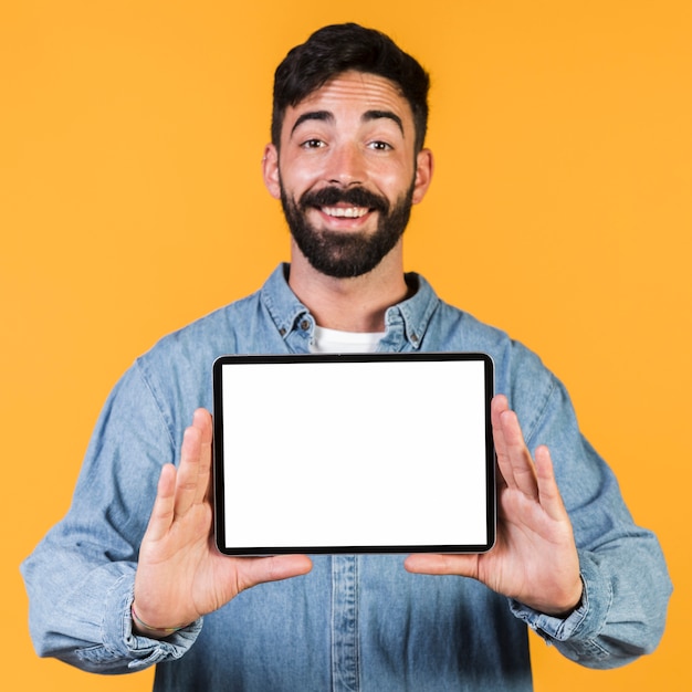 Front view happy guy holding a tablet