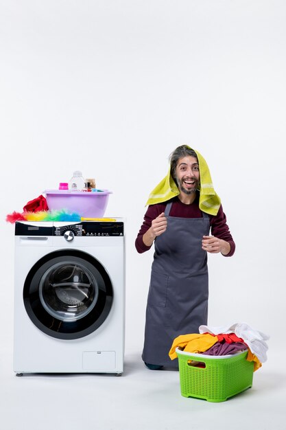 Front view happy housekeeper man standing on knee laundry on his head on white background