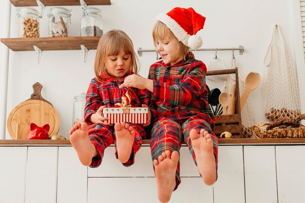 Front view happy kids holding christmas gift