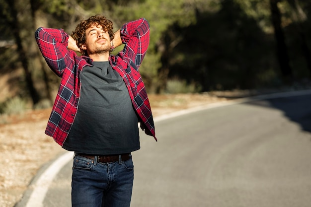 Free photo front view of happy man enjoying nature while on a road trip with copy space