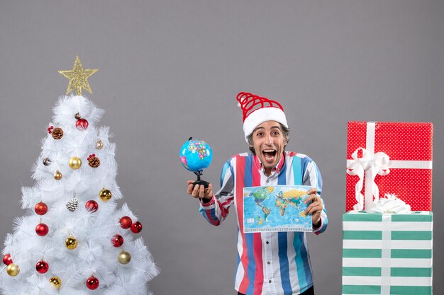 Front view happy man holding map and globe