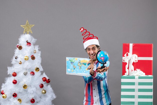 Front view happy man showing world map and globe