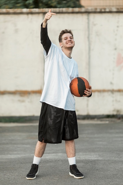 Foto gratuita vista frontale uomo felice con un pallone da basket