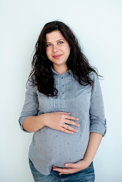 Free photo front view happy pregnant woman posing indoors