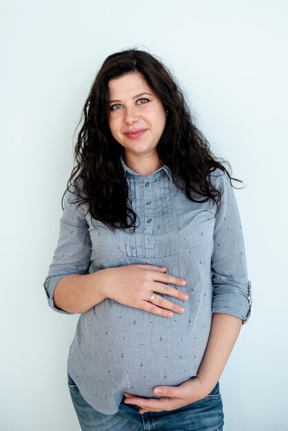 Front view happy pregnant woman posing indoors