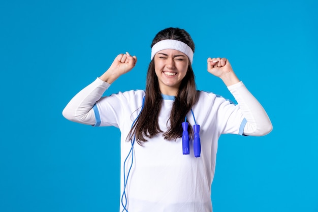 Femmina graziosa felice di vista frontale in vestiti di sport con la corda per saltare