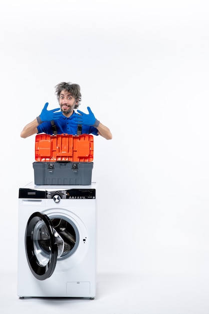 Free photo front view happy repairman opening hands behind washing machine on white space