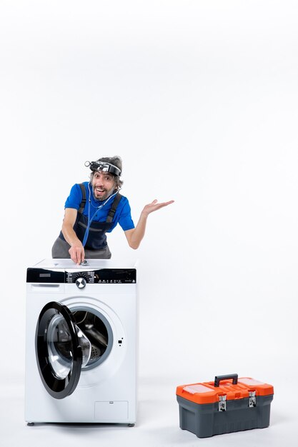 白いスペースの洗濯機に聴診器を置くヘッドランプと正面図幸せな修理工