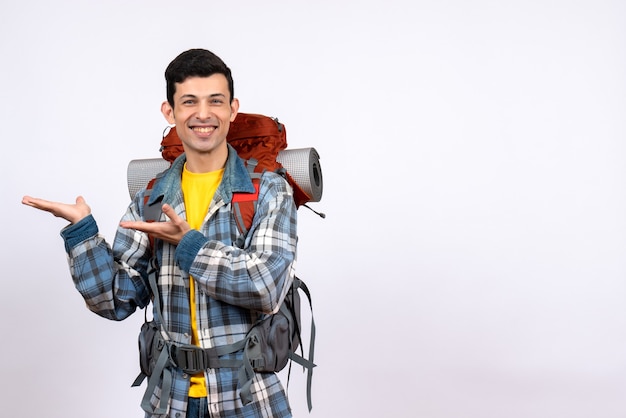 Front view happy traveler man with backpack pointing at something