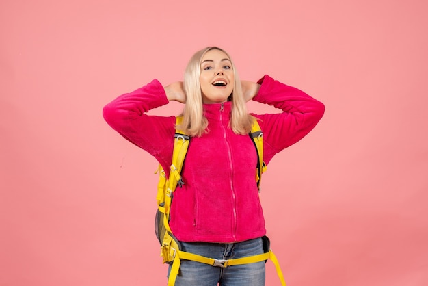 Front view happy traveler woman in casual clothes standing on pink wall