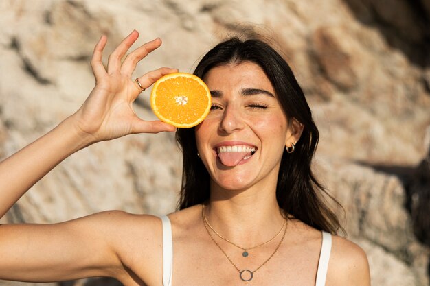 Front view happy woman holding orange