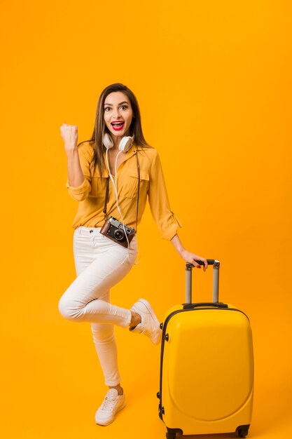 Front view of happy woman next to luggage